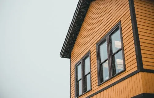 House exterior with warm wood-tone siding and dark window trim