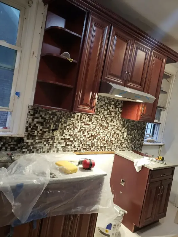 Kitchen renovation with dark wood cabinets and mosaic tile backsplash